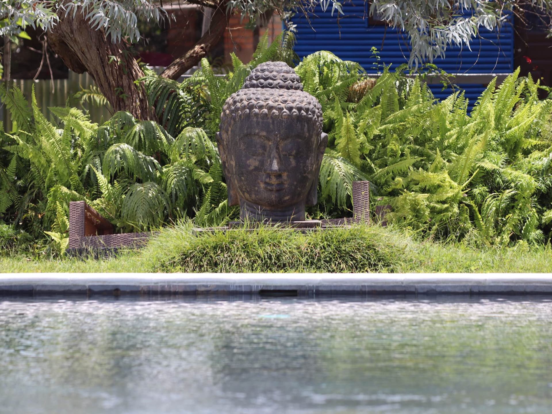 Tête de Bouddha au bord de la piscine en ardoise