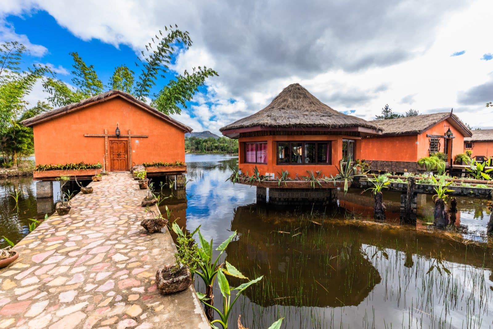 Allée pavée menant aux bungalows sur pilotis, au-dessus du lac Sahambavy