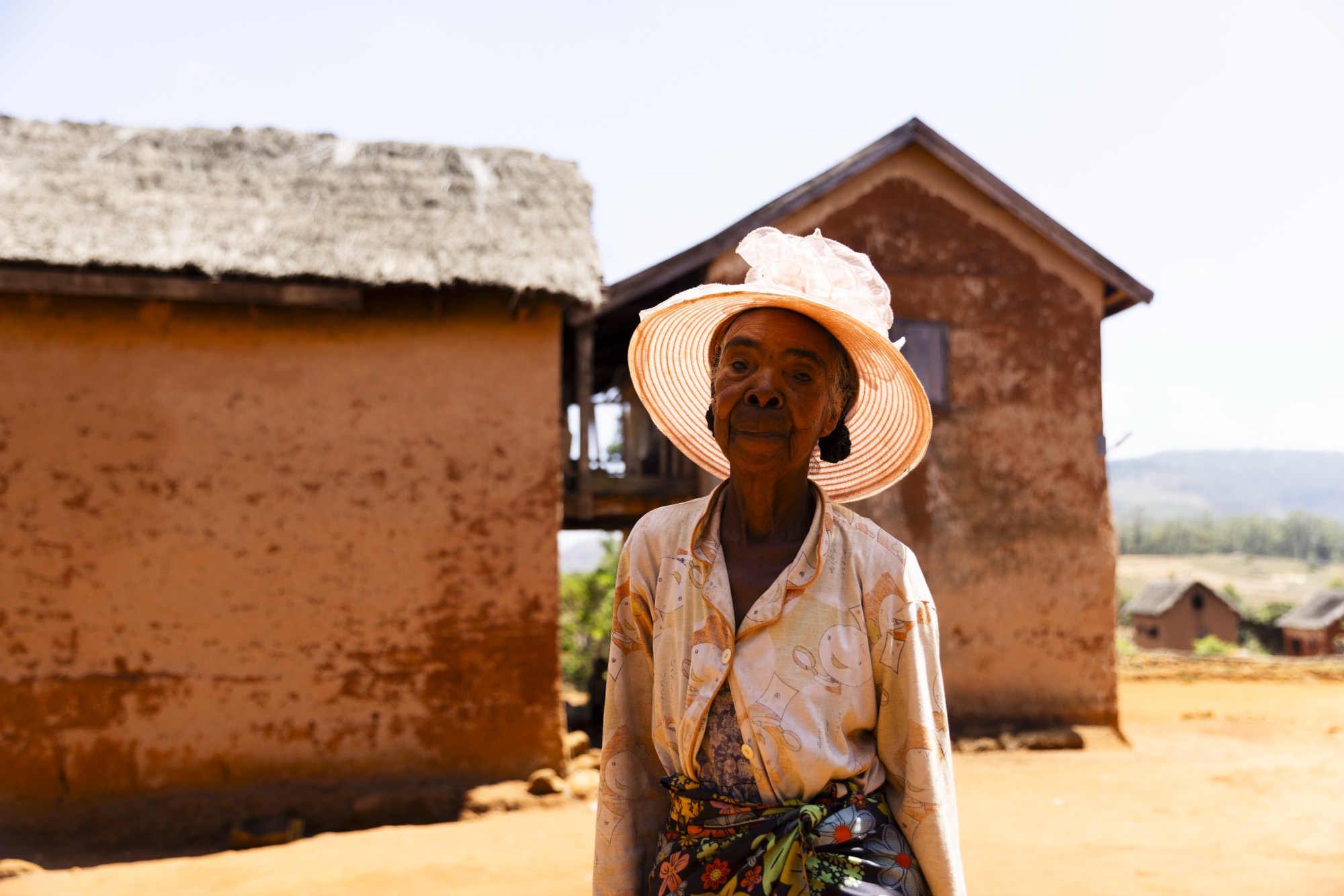 Femme betsileo devant une maison traditionnelle